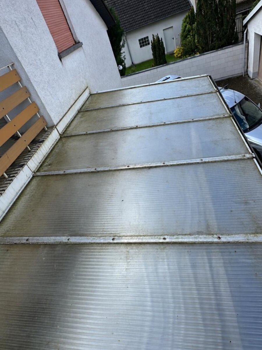 Verschmutztes, veralgtes Terrassendach vor der Reinigung